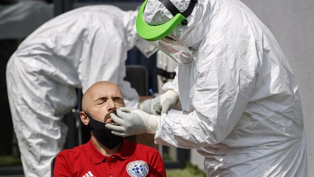Dos técnicos le hacen una prueba de coronavirus a un árbitro en Pristina, Kosovo, el pasado 30 de mayo - EFE